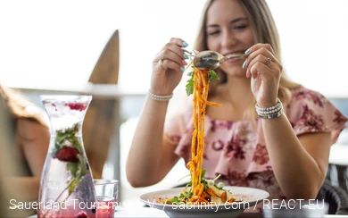 Eine Frau im Restaurant am Möhnesee. Seeblick. Ein Teller Spaghetti Bolognese vor ihr