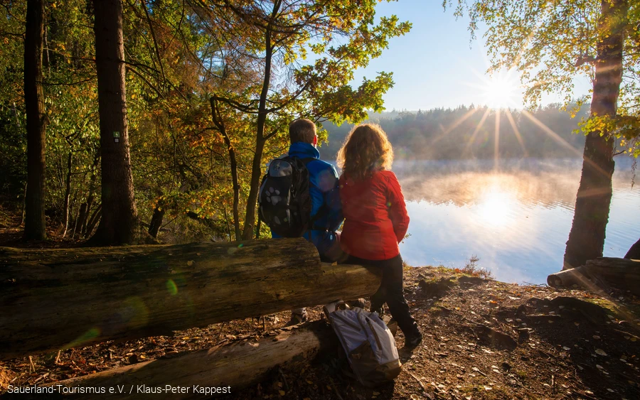 Ein Pärchen sitzt am Möhnesee bei Sonnenaufgang Copyright Sauerland-Tourismus e.V. / Klaus-Peter Kappest