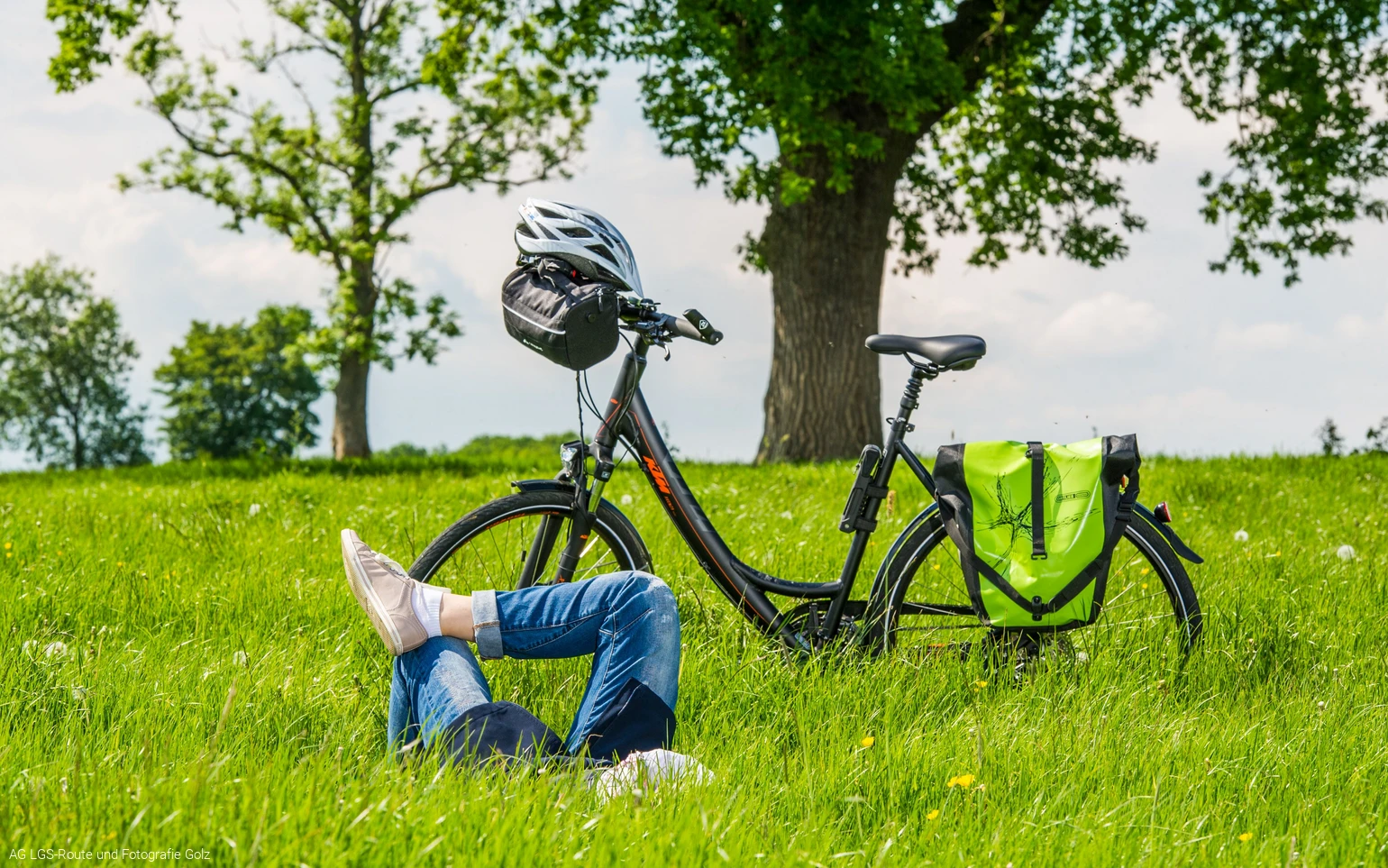 Frau liegend auf Wiese, daneben Fahrrad Foto: AG LGS-Route und Fotografie Golz